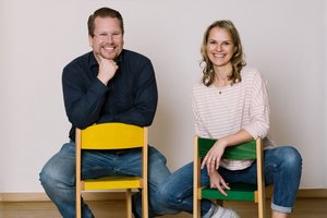 Zwei Personen auf kleinen Stühlen