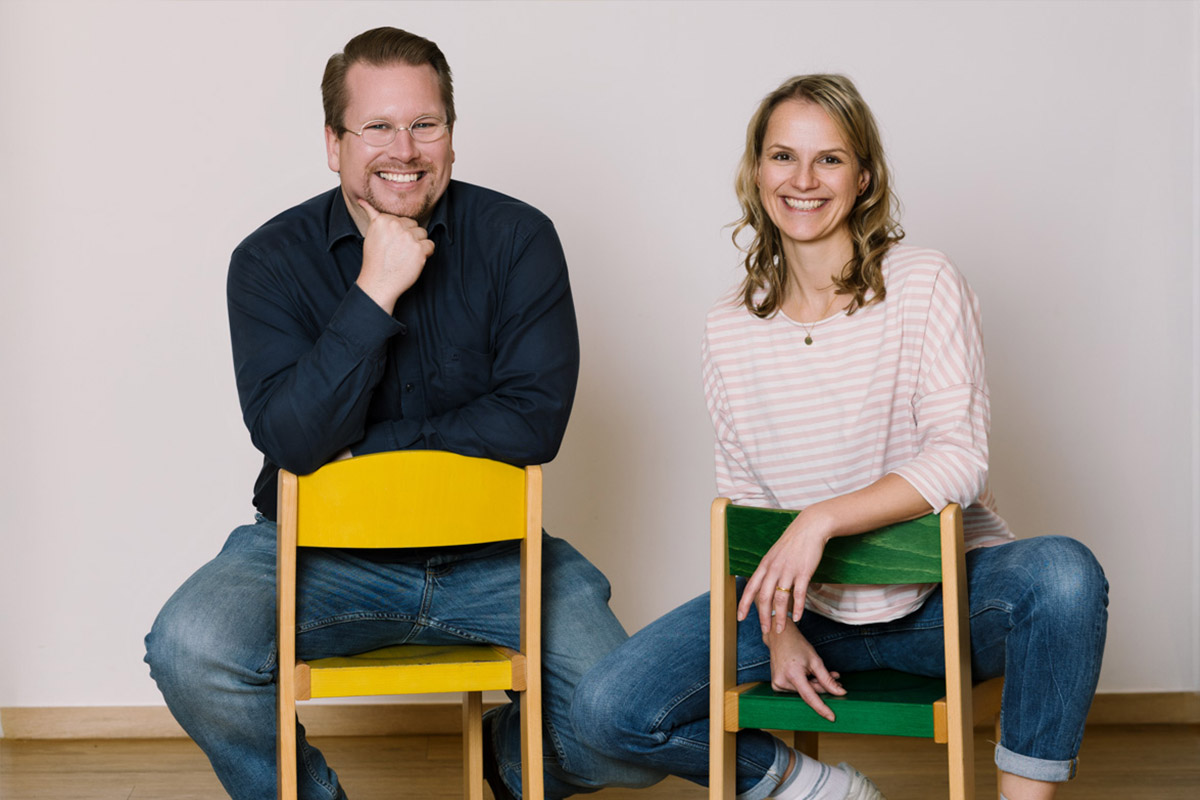 Zwei Personen auf kleinen Stühlen